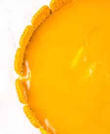 No bake cookie butter cheesecake with smooth cookie butter topping in a pie dish.