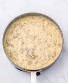Creamy sausage gravy simmering in a skillet.