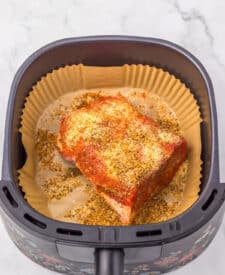 Seasoned eye of round roast placed in the air fryer basket.