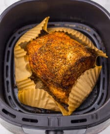 Air fryer eye of round roast developing a browned crust while cooking.