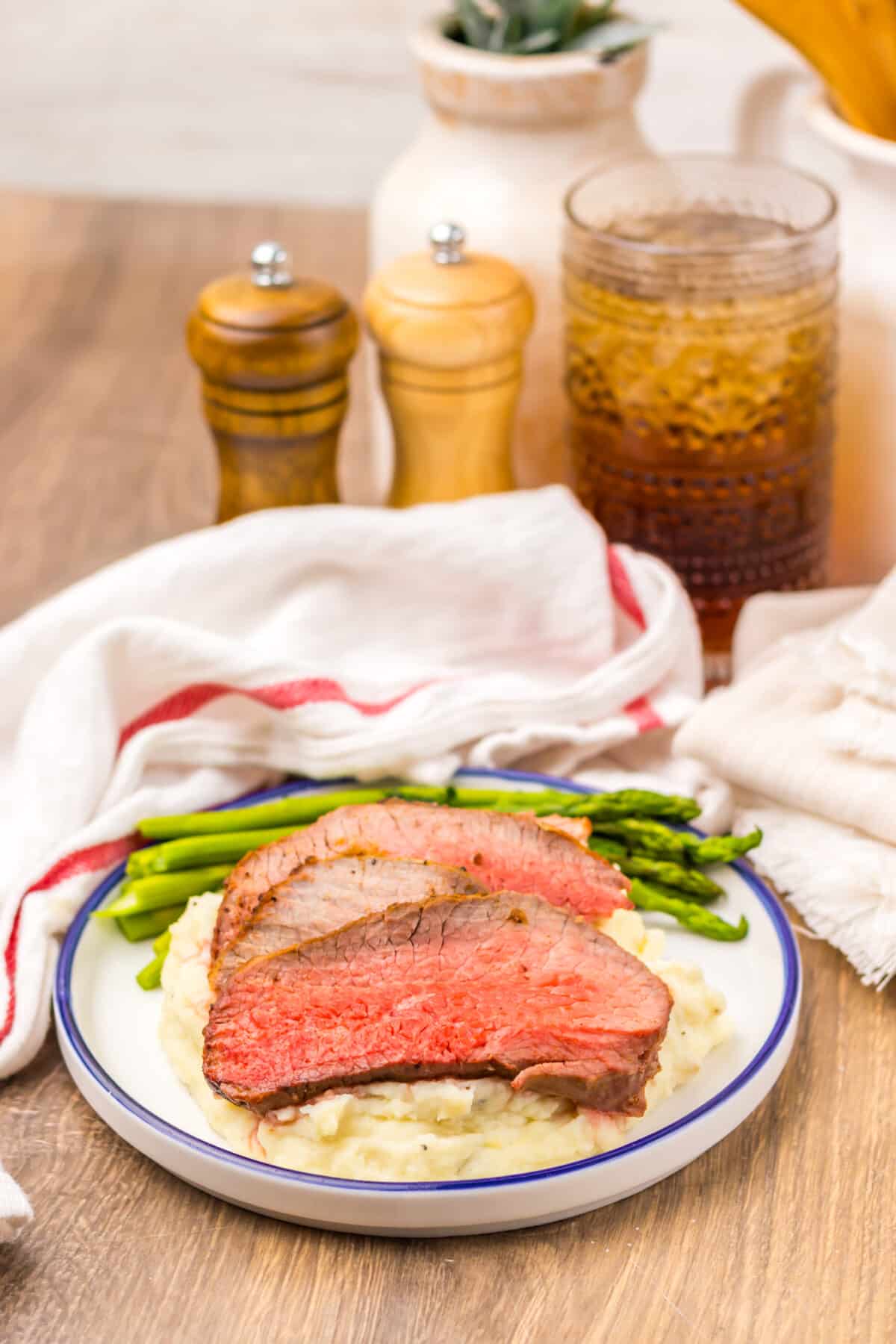 Sliced air fryer eye of round roast arranged on a plate.