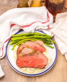 Air fryer eye of round roast served with mashed potatoes and green vegetables.