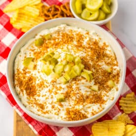 Close-up of fried pickle dip in a bowl with crispy topping.