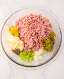 Ingredients for old fashioned ham salad including chopped ham, mayonnaise, relish, celery, onion, and seasonings.