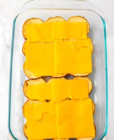 Slider buns arranged in a baking dish for assembling sliders.
