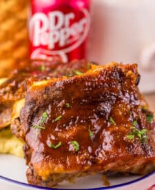 Stacked ribs with thick barbecue sauce dripping over the sides.