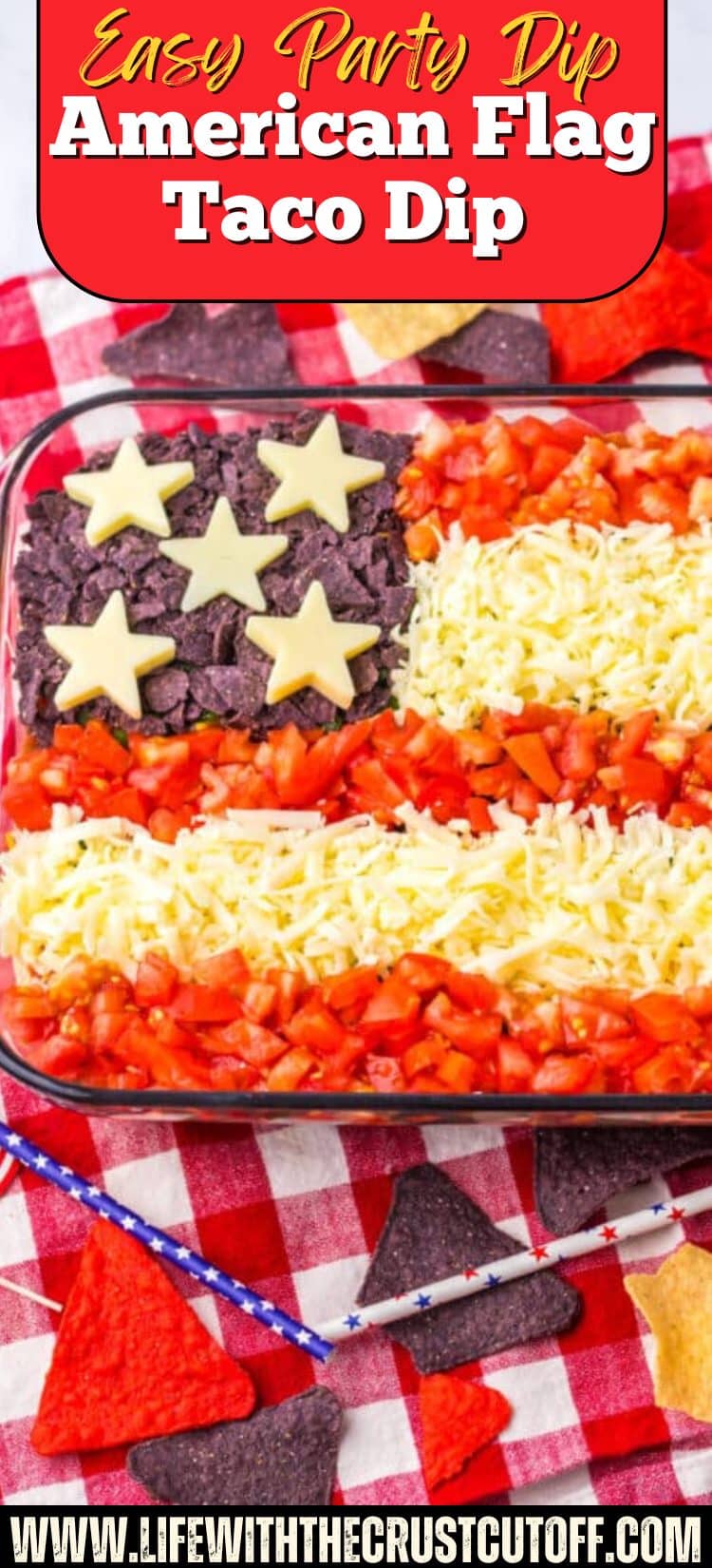 American Flag Taco Dip decorated with tomatoes, cheese, blue tortilla chips, and cheese stars in a patriotic flag design.