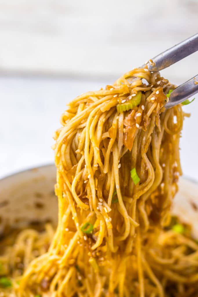 Close-up of copycat Panda Express chow mein noodles lifted with chopsticks.