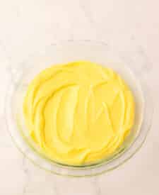 Smooth lemon curd poured into a bowl to cool.