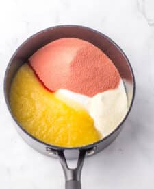 Colored gelatin mixture heating in a saucepan.