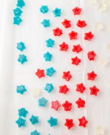 Red and blue star-shaped gumdrops set on parchment paper.