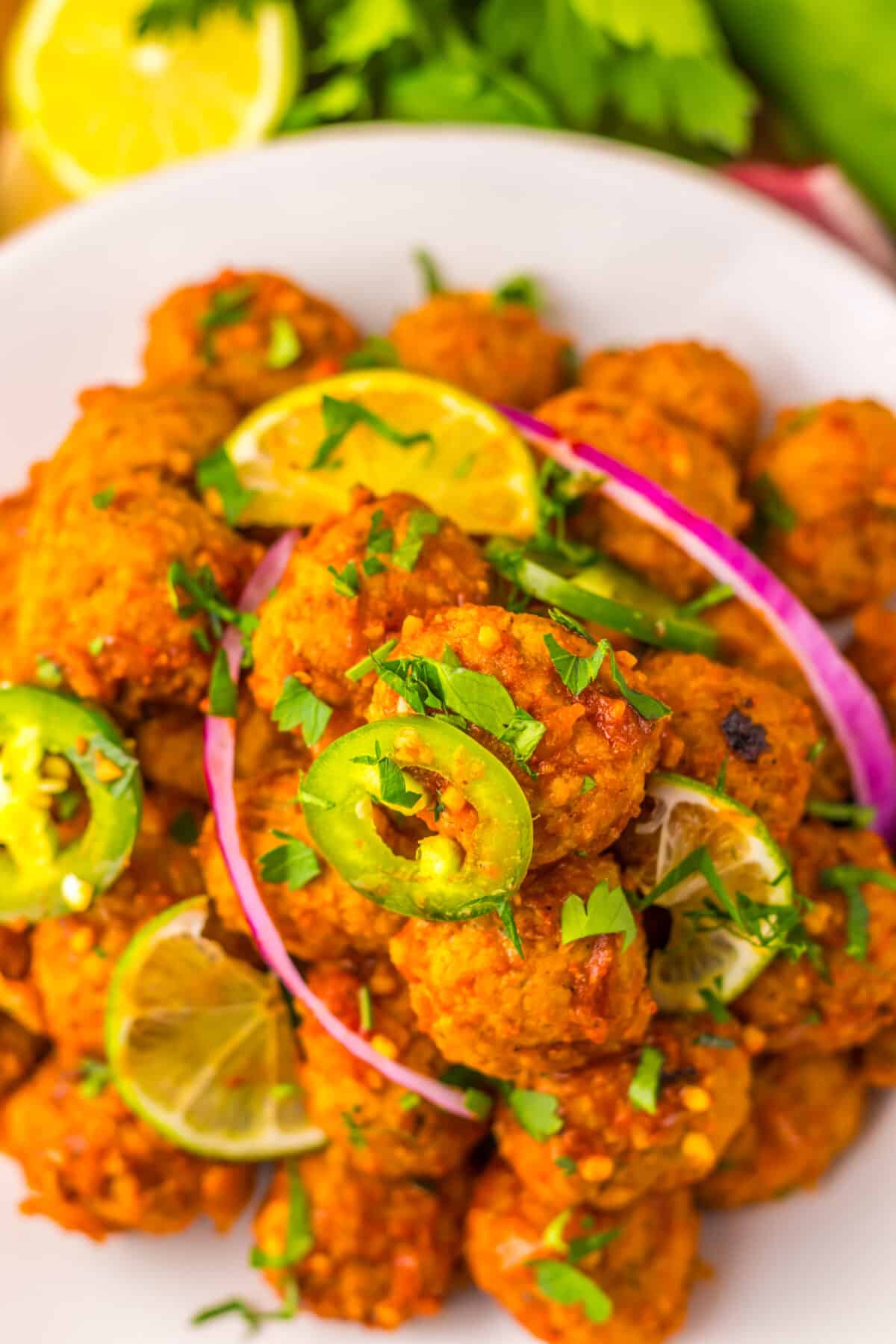 Close-up of tender birria meatballs coated in flavorful sauce.