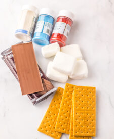 Ingredients for 4th of July S'mores Dip including chocolate bars, marshmallows, and colored sanding sugar.