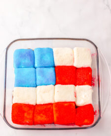 Marshmallows dipped in colored sanding sugar for patriotic s'mores dip.