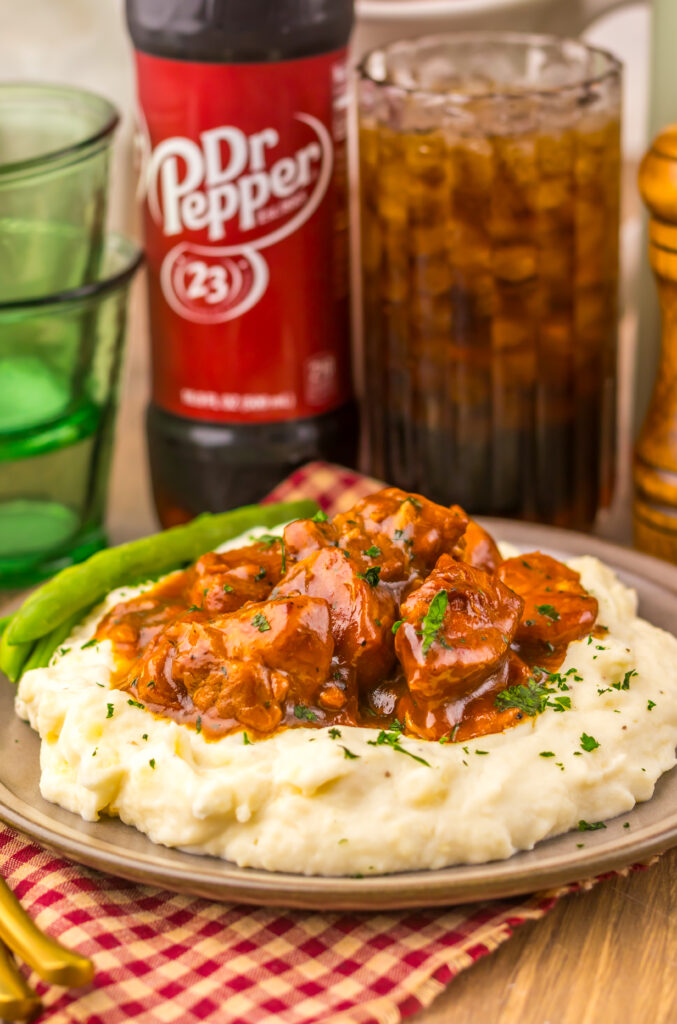 Fork lifting a bite of tender Slow Cooker Dr Pepper BBQ Rib Bites with mashed potatoes.