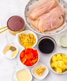 Ingredients for Slow Cooker Sweet Chili Pineapple Chicken including chicken, pineapple, sweet chili sauce, bell peppers, and seasonings.