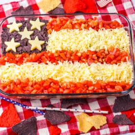 Red, white, and blue taco dip with cheese stars and tomato stripes.