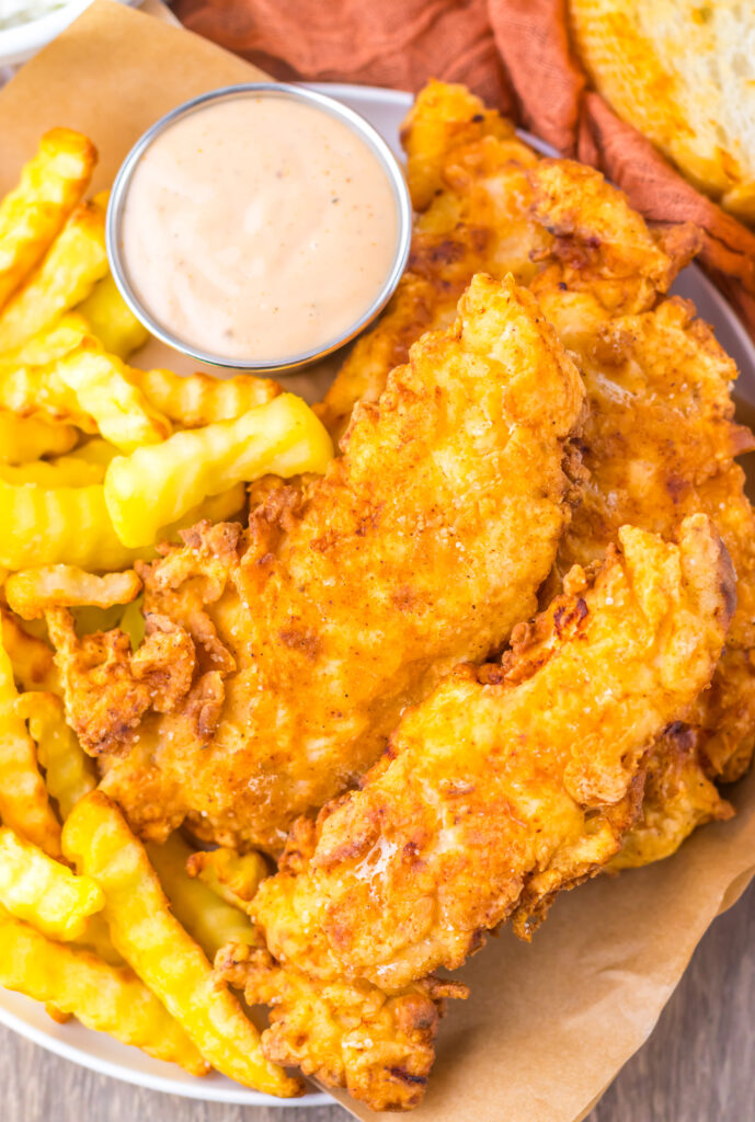 Copycat Raising Cane's chicken tenders served with fries, Texas toast, and Cane's sauce.