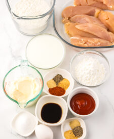 Ingredients for Copycat Raising Cane's Chicken Tenders including chicken tenders, buttermilk, flour, and seasonings.