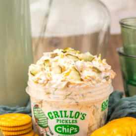 Viral Pickle Dip topped with shredded cheddar cheese and chopped pickles.