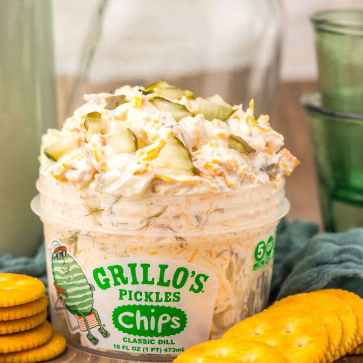 Close-up of creamy Viral Pickle Dip garnished with pickles and cheddar cheese.