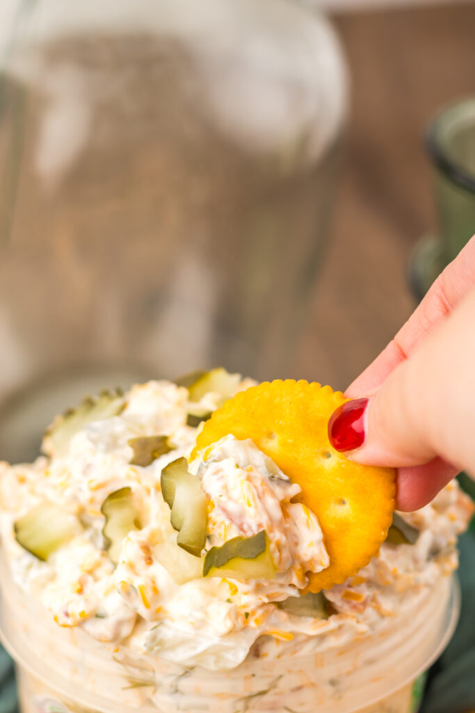Cracker dipped into creamy Viral Pickle Dip loaded with dill pickles and cheddar cheese.