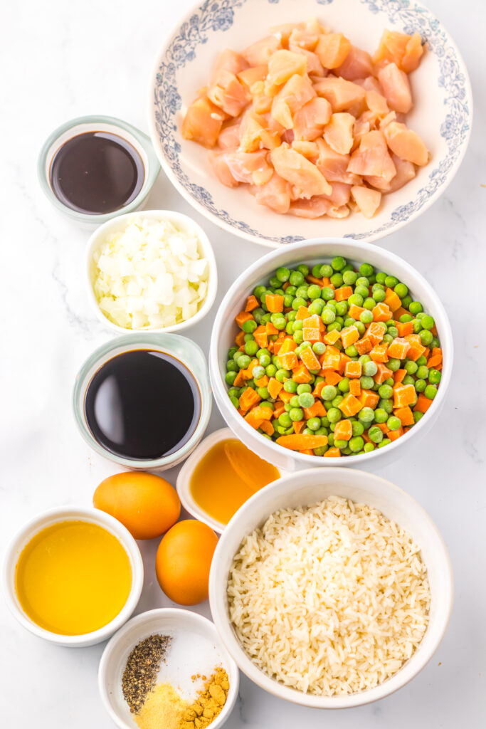 Ingredients for Slow Cooker Chicken Fried Rice including chicken, rice, vegetables, eggs, soy sauce, and seasonings.