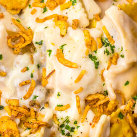 Close-up of Slow Cooker French Onion Ravioli with crispy onions and melted cheese.