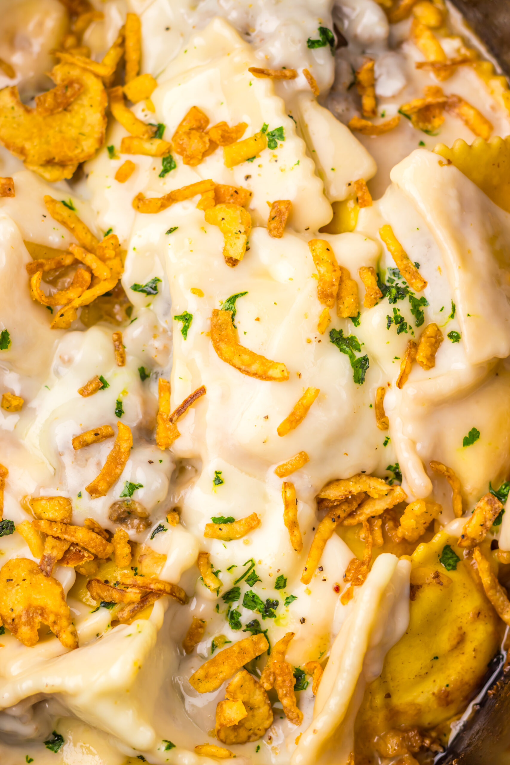 Close-up of Slow Cooker French Onion Ravioli with crispy onions and melted cheese.