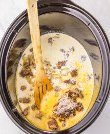 French onion soup and broth stirred together in the slow cooker.