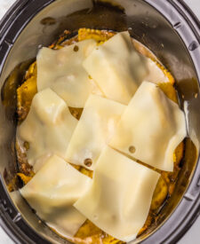 Slices of swiss cheese layered over ravioli before cooking.