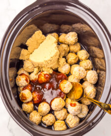 Frozen meatballs with root beer, barbecue sauce, and seasonings ready for the slow cooker.