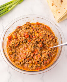 Chili cheese enchilada filling served with flour tortillas for an easy slow cooker dinner.