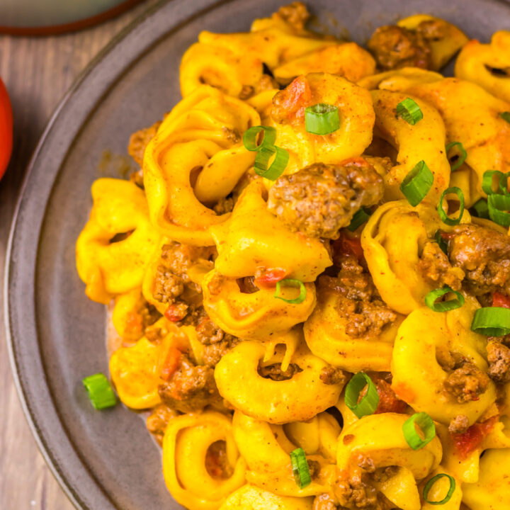 Close-up of Slow Cooker Taco Tortellini with cheesy tortellini, taco beef, and green onions.