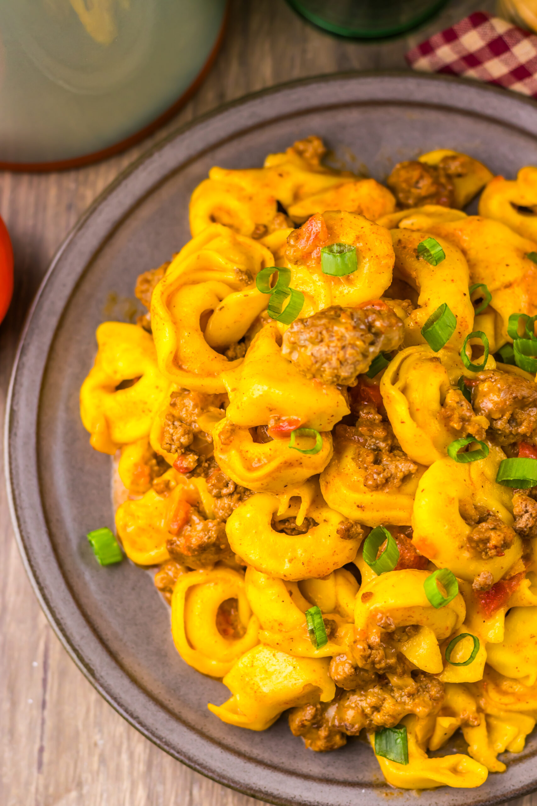 Close-up of Slow Cooker Taco Tortellini with cheesy tortellini, taco beef, and green onions.