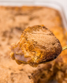 Warm Snickerdoodle Cobbler scooped from the baking dish with a golden cinnamon sugar topping.