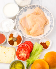 Ingredients for Copycat Chick-fil-A Spicy Deluxe Chicken Sandwich including chicken breasts, seasonings, and breading.