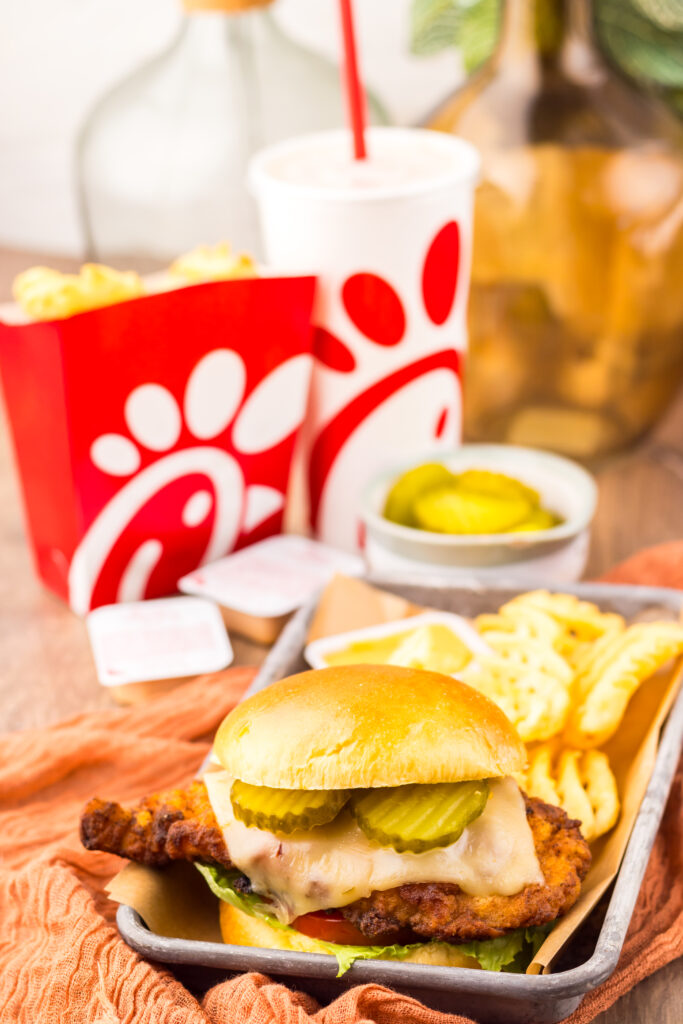 Copycat Chick-fil-A Spicy Deluxe Chicken Sandwich served with golden waffle fries and sauce.