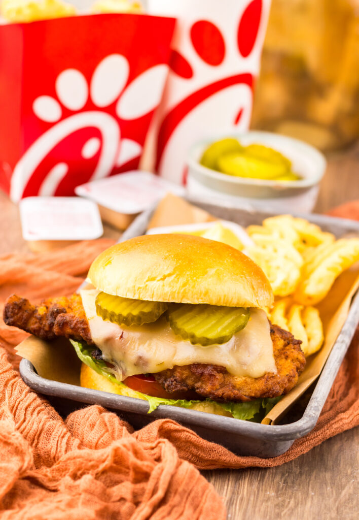 Close-up of a homemade Chick-fil-A Spicy Deluxe Chicken Sandwich served with waffle fries.