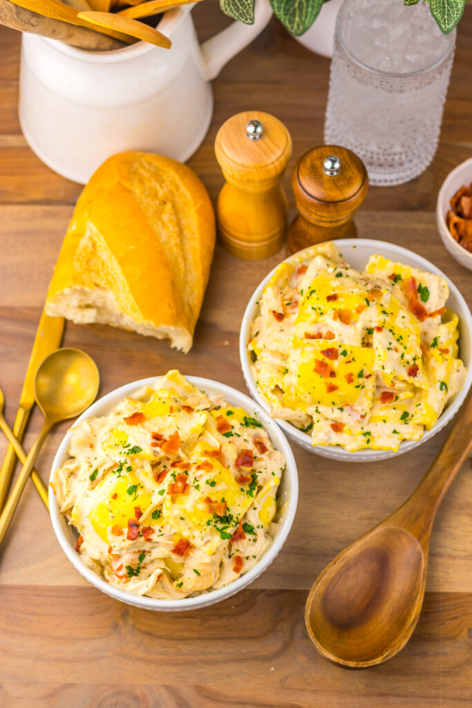 Close-up of creamy chicken Alfredo ravioli served with golden bread.