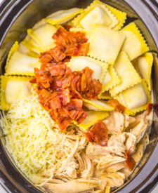 Cheese ravioli and crumbled bacon added to the slow cooker with creamy chicken Alfredo.