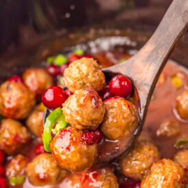 Cranberry Jalapeño Meatballs cooking in a glossy sweet and spicy sauce in the slow cooker.