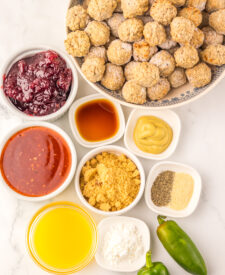 Ingredients for Slow Cooker Cranberry Jalapeño Meatballs including frozen meatballs, cranberry sauce, sweet chili sauce, and jalapeños.