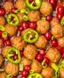 Slow Cooker Cranberry Jalapeño Meatballs topped with fresh jalapeño slices and cranberries.