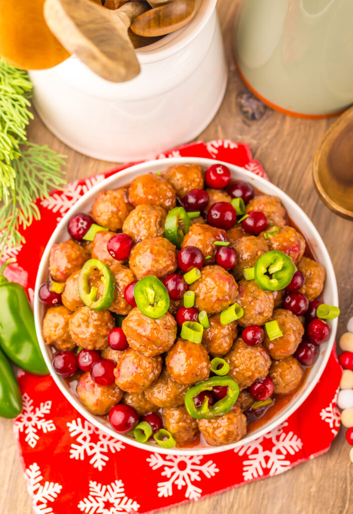 Finished Slow Cooker Cranberry Jalapeño Meatballs served in a bowl with sliced jalapeños.