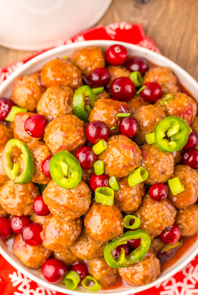 Glossy Cranberry Jalapeño Meatballs coated in a sweet and tangy cranberry sauce.