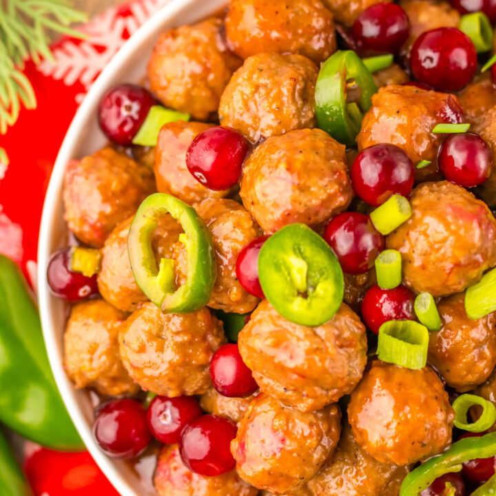 Close-up of Slow Cooker Cranberry Jalapeño Meatballs garnished with fresh green jalapeños.