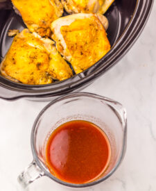 Seasoned chicken thighs arranged in the slow cooker for Honey Bourbon Chicken.