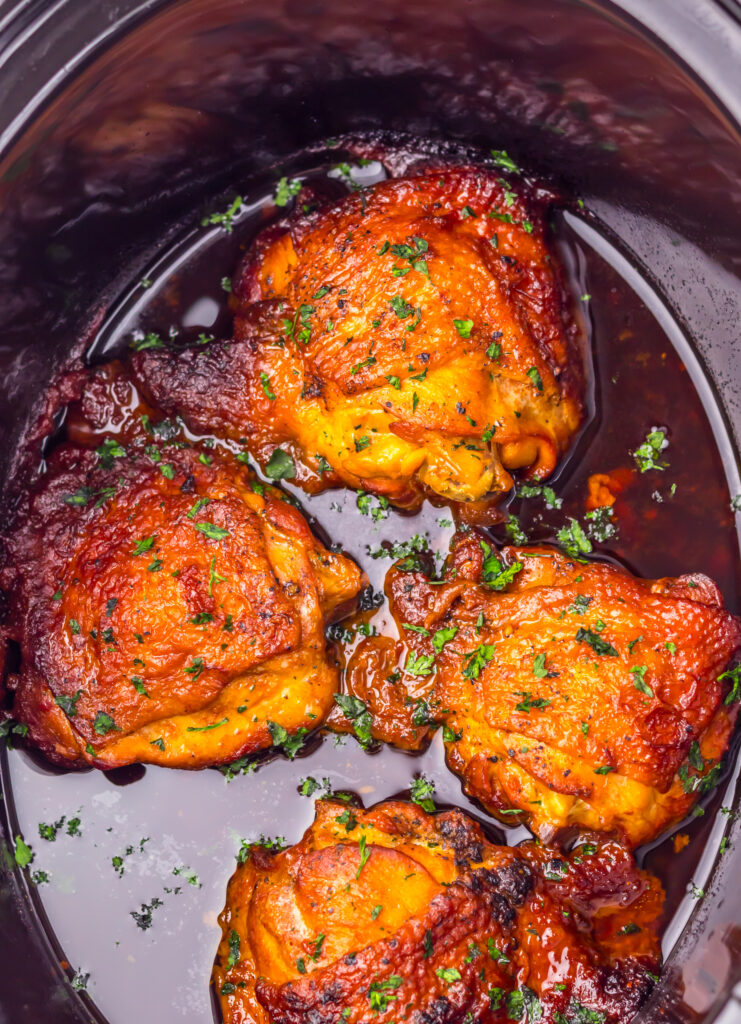 Slow Cooker Honey Bourbon Chicken Thighs cooking in a sweet and savory bourbon sauce.